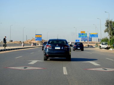 Kahire, Mısır, 26 Kasım 2022: Kahire Havalimanı yakınlarındaki Mısır otoyolu asfalt üzerinde bir yol uçağı tabelasıyla gürültü ve titreşim olasılığını gösteren alçaktan uçan uçaklar.