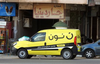 Kahire, Mısır, 25 Kasım 2022: Öğlen çevrimiçi alışveriş sarı minibüsü Arapça Çeviri (Noon.com hızlı teslimat ve kolay dönüş için ekspres), Noon bir e-ticaret şirketidir.