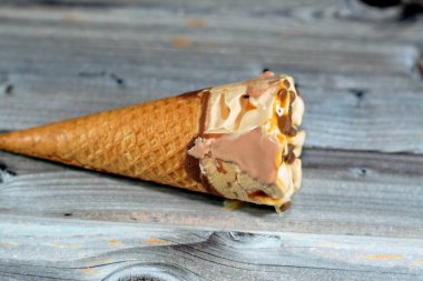 Kakao çikolatalı dondurma ve çikolata parçalı dondurma külahı. Çıtır gofret külahında çikolata parçacıkları. Soğuk dondurmayı bisküvinin içinde eritmenin seçici odak noktası.