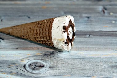 Çikolata parçalı dondurma külahlı dondurma külahı, gevrek külahta erimiş soğuk dondurmanın seçici odak noktası waffle bisküvileri, yaz tatili konsepti.