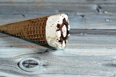Çikolata parçalı dondurma külahlı dondurma külahı, gevrek külahta erimiş soğuk dondurmanın seçici odak noktası waffle bisküvileri, yaz tatili konsepti.