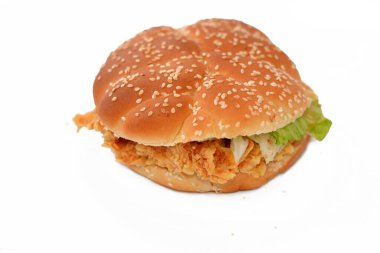 Kızarmış susamlı çörek, çıtır çıtır tavuklu sandviç, abur cubur konseptinin seçici odak noktası olan kızarmış tavuk filetosu ve marul ve mayonez ile kaplı baharatlı tavuk filetosu.