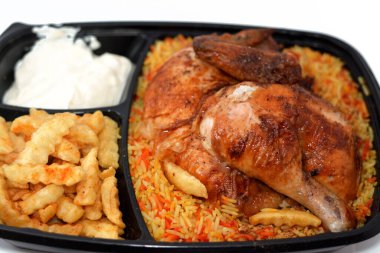 Arap mutfağından ızgara ızgara tavuk rengarenk Basmati pilavı ve patates kızartması sarımsak sosuyla servis edilen siyah bir tek kullanımlık tabakta servis ediliyor.