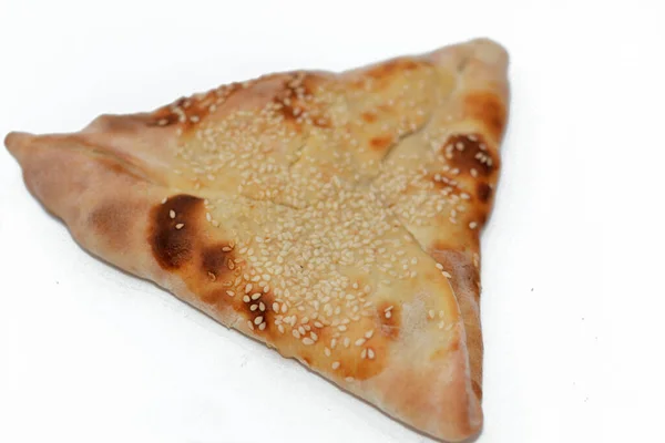 焼き菓子の伝統的なアラビア料理Manakishと呼ばれる中東のパンは ゴマで覆われ オーブンで焼かれたサンドイッチのようなトルコのスライスを燻製にしたピザに似ています — ストック写真