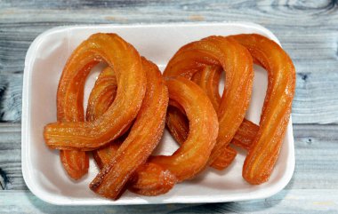 Türk Churros, Türkiye 'de çok popüler sokak yemekleri veya sokak tatlıları, Halka Tatlisi yağda kızartılmış ve bal şurubuyla tatlandırılmış dairesel tatlı, halka tatlisi Sweet Churros' un seçici odak noktası