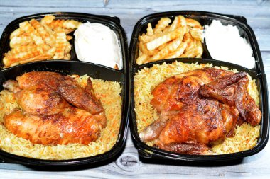 Arap mutfağından ızgara ızgara tavuk rengarenk Basmati pilavı ve patates kızartması sarımsak sosuyla servis edilen siyah bir tek kullanımlık tabakta servis ediliyor.