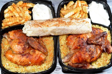 Arap mutfağından ızgara ızgara tavuk rengarenk Basmati pilavı ve patates kızartması patates kızartması ve tavuklu shawerma veya soğanlı, domatesli, marullu shawarma tortilla dürümü.
