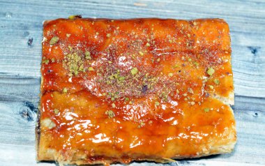 Elmalı turta, kremalı elma, tarçın ve şekerli bal şurubuyla doldurulmuş ve üzerinde şam fıstığı olan lezzetli, tatlandırılmış elmalı turta servis edilmeye hazır, seçici bir odak noktası.