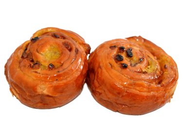 Tarçınlı kek rulosu balla tatlandırılmış ve kremayla doldurulmuş, hamur işlerinin seçici odağı kruvasan kruvazörü yalnız ve servis edilmeye hazır.