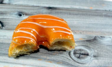 Beyaz çikolata soslu mango aromalı halka donut, jöleli, mayalı, Amerikan usulü yüzük donutu mayalanmış, hamur aromalı tatlı aperatif, seçici odaklı ve izole edilmiş