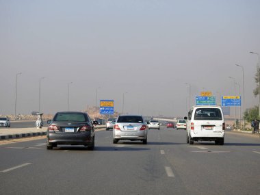 Kahire, Mısır, 10 Aralık 2022: Kahire Havalimanı yakınlarındaki Mısır otoyolu asfalt üzerinde bir yol uçağı tabelasıyla gürültü ve titreşim olasılığını gösteren alçaktan uçan uçaklar.