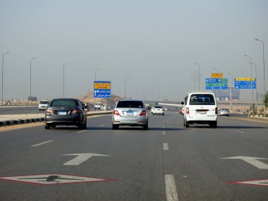 Kahire, Mısır, 10 Aralık 2022: Kahire Havalimanı yakınlarındaki Mısır otoyolu asfalt üzerinde bir yol uçağı tabelasıyla gürültü ve titreşim olasılığını gösteren alçaktan uçan uçaklar.