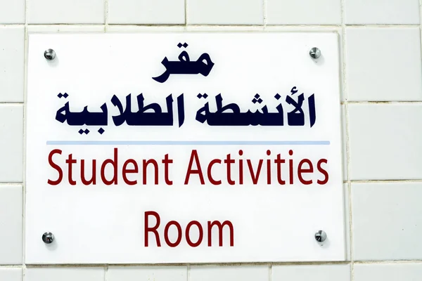 A side door sign written in Arabic and English, Translation (Student Activities Room), preschool, school and university students activity as an extracurricular clubs and programs offered by college