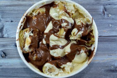 Muz, fındık, fındık, kuru üzüm, beyaz ve siyah çikolata karışımlı çikolata soslu tatlı çikolata ruloları.