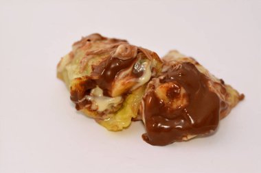 Muz, fındık, fındık, kuru üzüm, beyaz ve siyah çikolata karışımlı çikolata soslu tatlı çikolata ruloları.