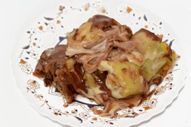 Muz, fındık, fındık, kuru üzüm, beyaz ve siyah çikolata karışımlı çikolata soslu tatlı çikolata ruloları.