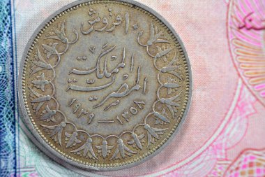 Ancient old ten 10 Egyptian piasters coin at the era of king Farouk I features value and kingdom of Egypt on a side and a bust of King Farouk the 1st on the other side, vintage retro coin 1939 AD
