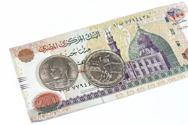 Background of old Egyptian money banknotes and coins of two hundred pounds 200 EGP LE banknote bill of Qani Bay mosque and coin of Orabi Revolution and 10 ten Egyptian piasters of king Farouk I first
