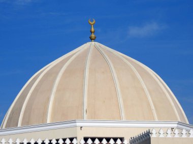 A big dome of a mosque against a lovely blue sky with clouds at the daylight, Mosques are the place for worship and prayers for Muslims where they perform 5 Islamic prayers daily, selective focus