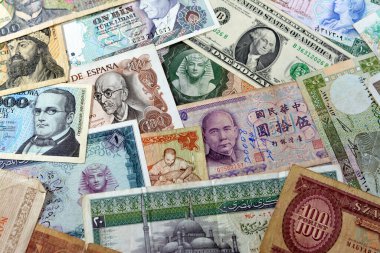 various old cash money banknotes from different countries of the world, stack of multiple currencies, pile of vintage retro bills of different origins with profiles of country leaders, ancient money
