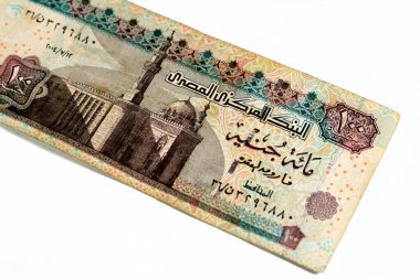 One hundred Egyptian pounds 100 EGP LE series 2004 features Sultan Hassan mosque on obverse side and Sphinx of Giza Egypt on the reverse, selective focus of old Egyptian banknote money bill