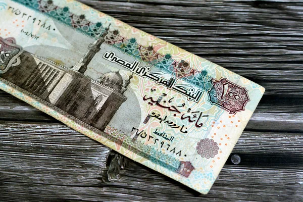 One hundred Egyptian pounds 100 EGP LE series 2004 features Sultan Hassan mosque on obverse side and Sphinx of Giza Egypt on the reverse, selective focus of old Egyptian banknote money bill