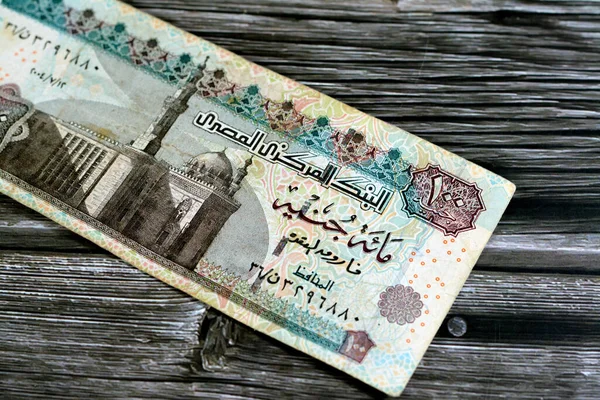 One hundred Egyptian pounds 100 EGP LE series 2004 features Sultan Hassan mosque on obverse side and Sphinx of Giza Egypt on the reverse, selective focus of old Egyptian banknote money bill