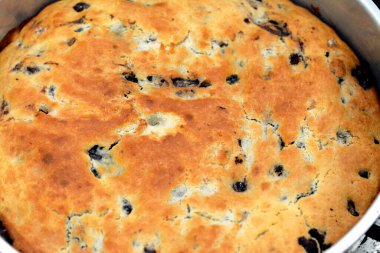 baked dough covered with chocolate and stuffed with pieces of chocolate, biscuit, cake, caramel and brownies, ready to be served, selective focus of a chocolate sweet pastry cake