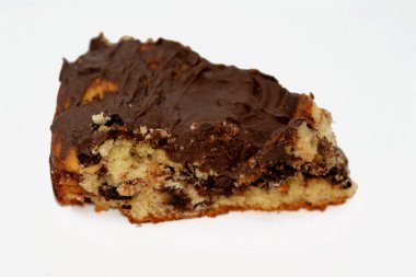 baked dough covered with chocolate and stuffed with pieces of chocolate, biscuit, cake, caramel and brownies, ready to be served, selective focus of a chocolate sweet pastry cake