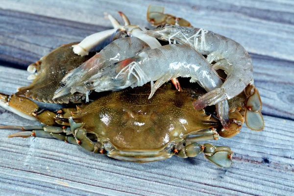 fresh gray crabs and shrimps ready to be cooked in a seafood meal soup or in sea food salad traditional meal, fresh crab and prawns isolated, selective focus
