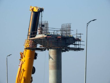 Cairo, Egypt, February 15 2023: Construction site of new Cairo monorail overhead transportation system that is still under construction with a heavy mobile crane fixing and fitting objects