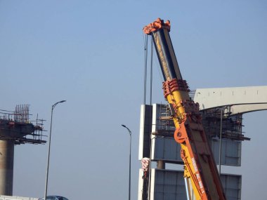 Cairo, Egypt, February 15 2023: Construction site of new Cairo monorail overhead transportation system that is still under construction with a heavy mobile crane fixing and fitting objects