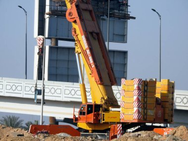 Cairo, Egypt, February 15 2023: Construction site of new Cairo monorail overhead transportation system that is still under construction with a heavy mobile crane fixing and fitting objects
