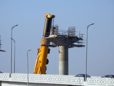 Cairo, Egypt, February 15 2023: Construction site of new Cairo monorail overhead transportation system that is still under construction with a heavy mobile crane fixing and fitting objects