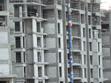 A construction site of new residential buildings and high rise with cranes to transport heaving objects, selective focus of an under construction buildings with cranes at daylight time