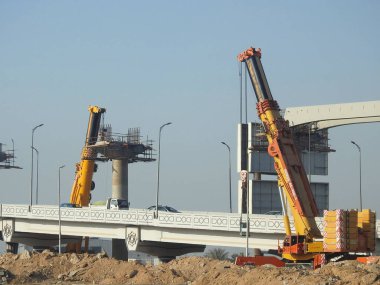 Cairo, Egypt, February 15 2023: Construction site of new Cairo monorail overhead transportation system that is still under construction with a heavy mobile crane fixing and fitting objects