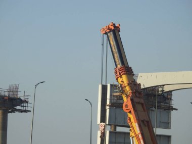 Cairo, Egypt, February 15 2023: Construction site of new Cairo monorail overhead transportation system that is still under construction with a heavy mobile crane fixing and fitting objects