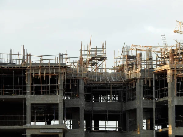 A construction site of new residential buildings and high rise with cranes to transport heaving objects, selective focus of an under construction buildings with cranes at daylight time