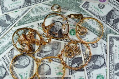 Jewellery or jewelry with USD American dollars cash money banknotes, brooches, rings, necklaces, earrings, pendants, bracelets, chain and cufflinks, Gold price in US dollar concept, selective focus