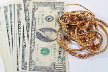 Jewellery or jewelry with USD American dollars cash money banknotes, brooches, rings, necklaces, earrings, pendants, bracelets, chain and cufflinks, Gold price in US dollar concept, selective focus