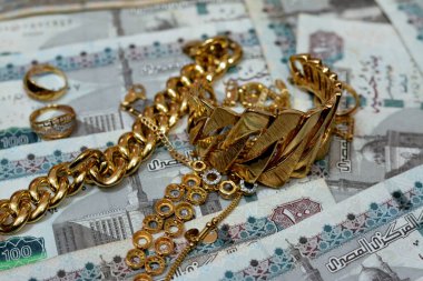 Jewellery or jewelry with EGP LE Egyptian pounds cash money banknotes, brooches, rings, necklaces, earrings, pendants, bracelets, chain and cufflinks, Gold price in Egyptian EGP LE pounds concept