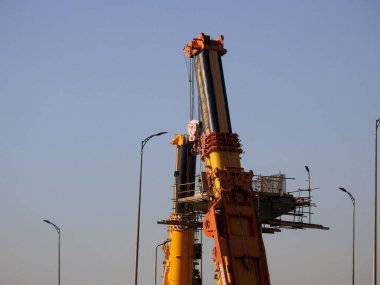Cairo, Egypt, February 16 2023: Construction site of new Cairo monorail overhead transportation system that is still under construction with a heavy mobile crane fixing and fitting objects
