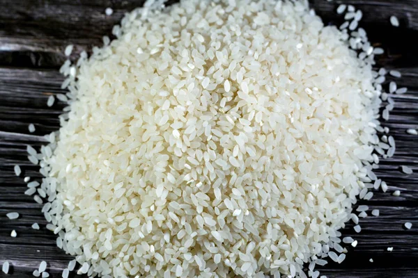 A pile of raw short grain white rice, White rice is milled rice that has had its husk, bran, and germ removed, seeds are with a bright, white, shiny appearance, selective focus of uncooked rice