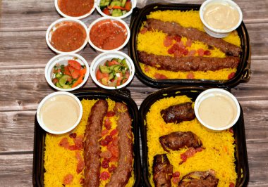 Arabic cuisine traditional food beef  Kofta, kebab and tarb kofta shish which is minced meat with Basmati rice and raisins, oriental grilled barbecued meat food with long yellow rice, selective focus