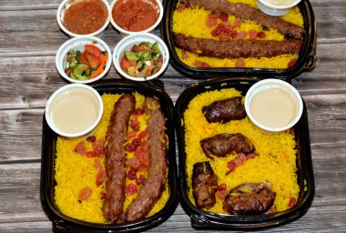 Arabic cuisine traditional food beef  Kofta, kebab and tarb kofta shish which is minced meat with Basmati rice and raisins, oriental grilled barbecued meat food with long yellow rice, selective focus