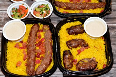 Arabic cuisine traditional food beef  Kofta, kebab and tarb kofta shish which is minced meat with Basmati rice and raisins, oriental grilled barbecued meat food with long yellow rice, selective focus