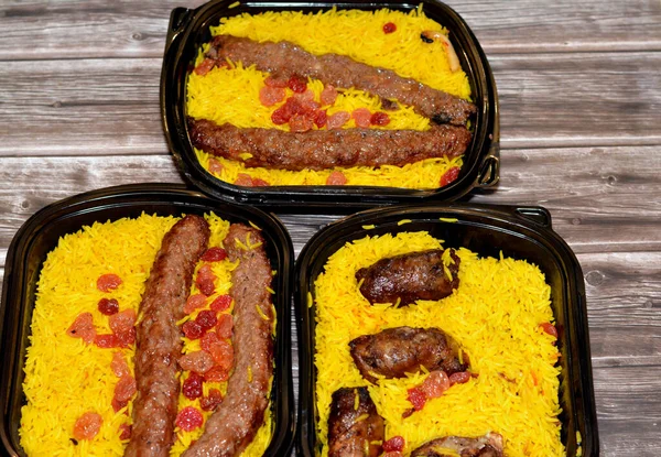 Arabic cuisine traditional food beef  Kofta, kebab and tarb kofta shish which is minced meat with Basmati rice and raisins, oriental grilled barbecued meat food with long yellow rice, selective focus