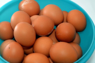 Pile of organic brown fresh and raw hen chicken eggs, stack of eggs isolated and ready to be cooked in various cuisines, selective focus of eggs which consists of egg yolk and white part albumen