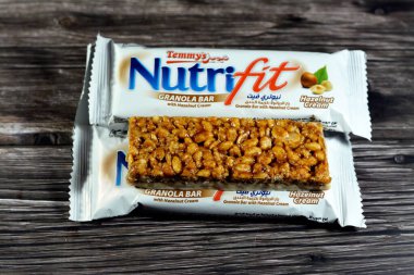 Cairo, Egypt, February 10 2023: Nutrifit granola bar with hazelnut cream, sweet sugary snack, sweetness and aromas of Apple Pie, selective focus of delicious candy of mixed granola and hazelnut