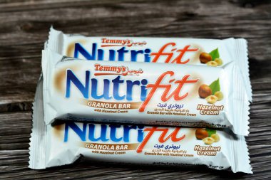 Cairo, Egypt, February 10 2023: Nutrifit granola bar with hazelnut cream, sweet sugary snack, sweetness and aromas of Apple Pie, selective focus of delicious candy of mixed granola and hazelnut